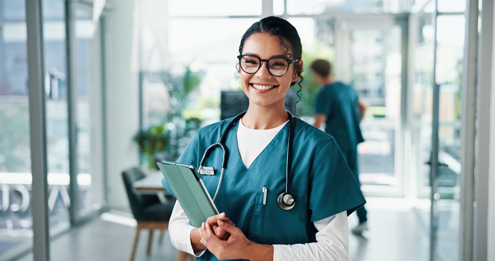 A smiling nurse with a tablet